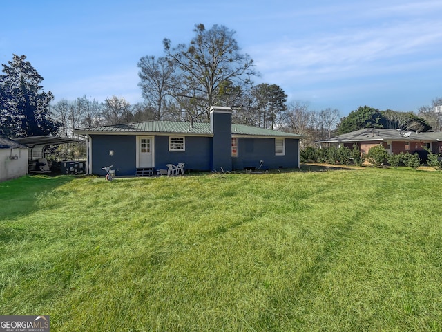 rear view of property featuring a lawn