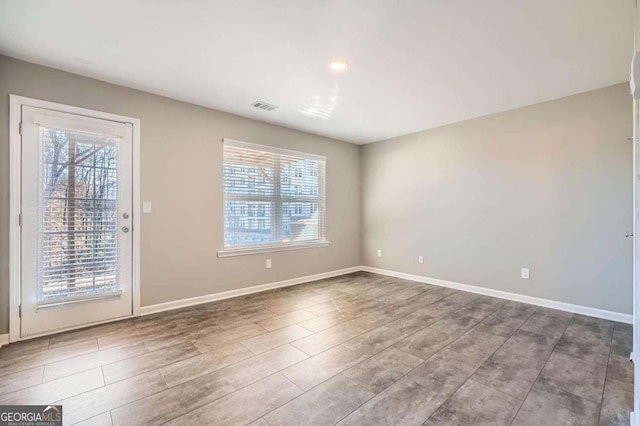 empty room with hardwood / wood-style flooring and a healthy amount of sunlight