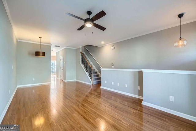 unfurnished living room featuring wood-type flooring, ceiling fan, and crown molding