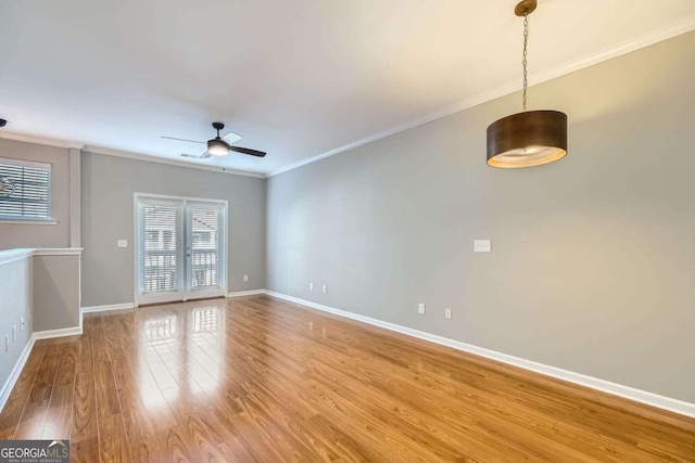 empty room with ceiling fan, wood-type flooring, and crown molding