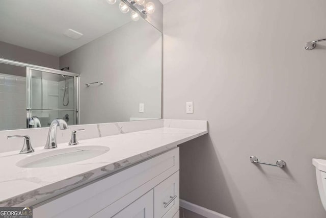 bathroom featuring vanity, toilet, and walk in shower