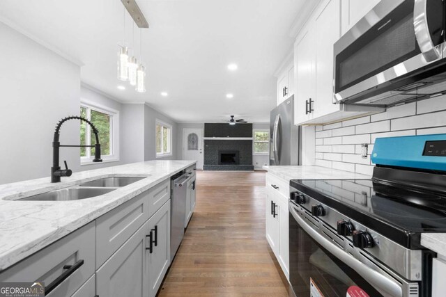 kitchen with white cabinets, sink, ceiling fan, tasteful backsplash, and stainless steel appliances