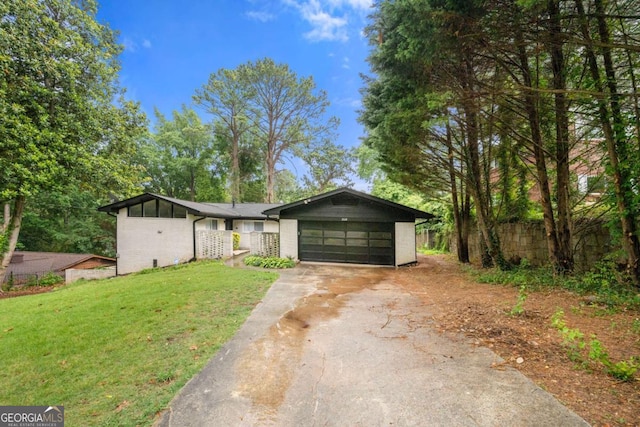 ranch-style house featuring a garage and a front lawn