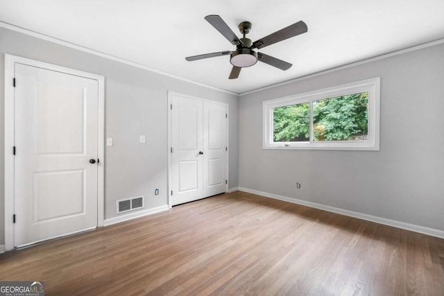 unfurnished bedroom with ceiling fan, light hardwood / wood-style floors, and ornamental molding