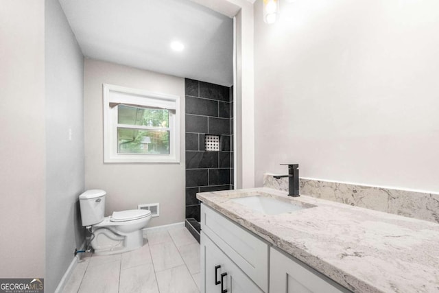 bathroom featuring vanity, toilet, and a shower