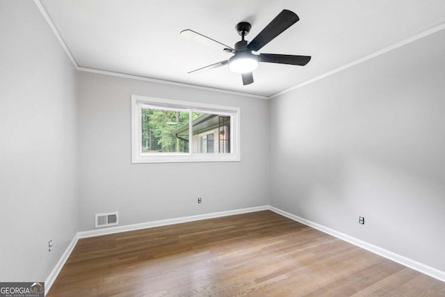 empty room featuring ornamental molding and hardwood / wood-style flooring