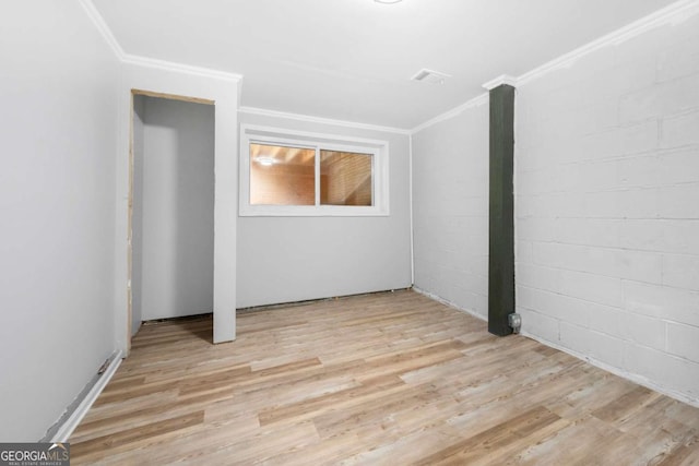 spare room featuring light wood-type flooring and ornamental molding