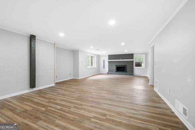 unfurnished living room featuring a fireplace, wood-type flooring, and ornamental molding