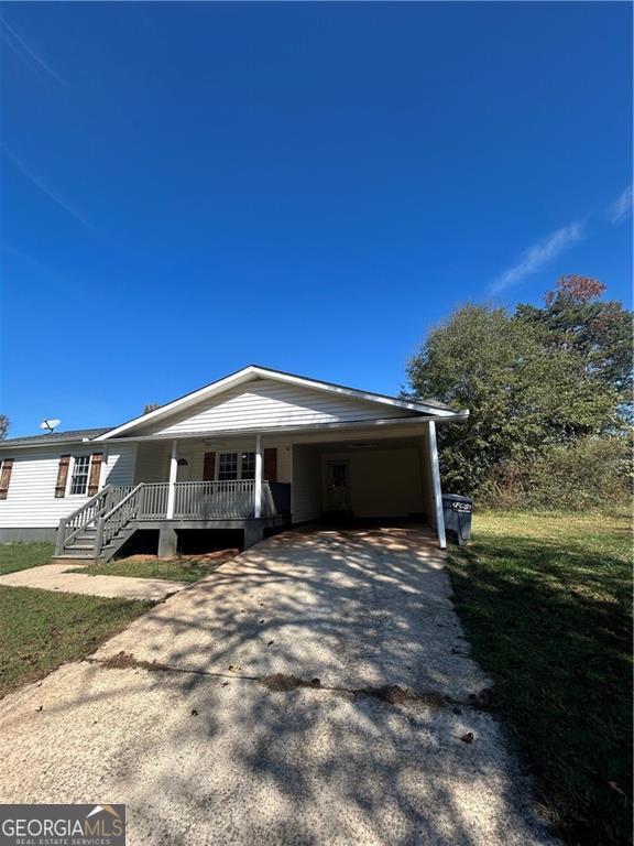 view of front facade with a front lawn and a carport