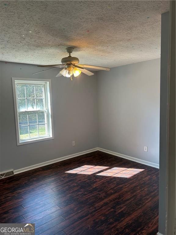 spare room featuring ceiling fan, dark hardwood / wood-style flooring, and a textured ceiling