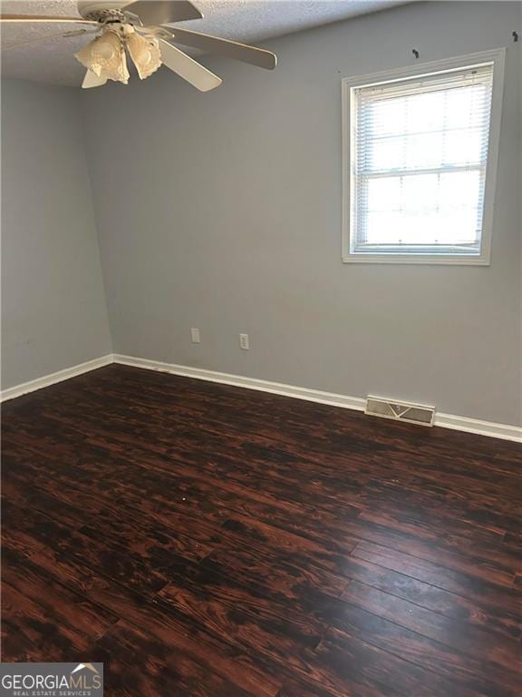 unfurnished room with ceiling fan, wood-type flooring, and a textured ceiling