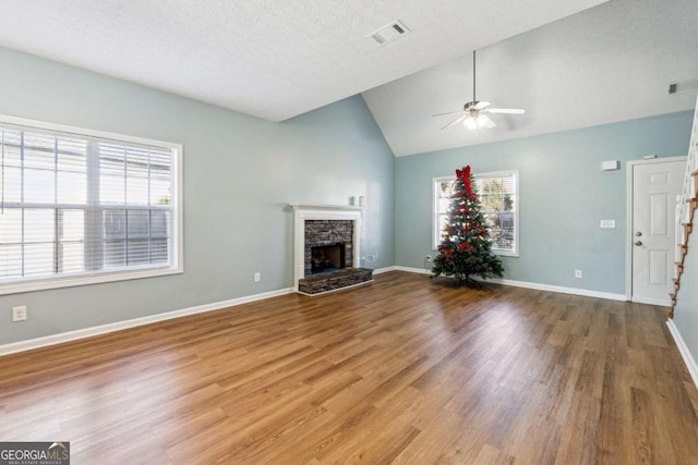 unfurnished living room with hardwood / wood-style floors, vaulted ceiling, and a healthy amount of sunlight