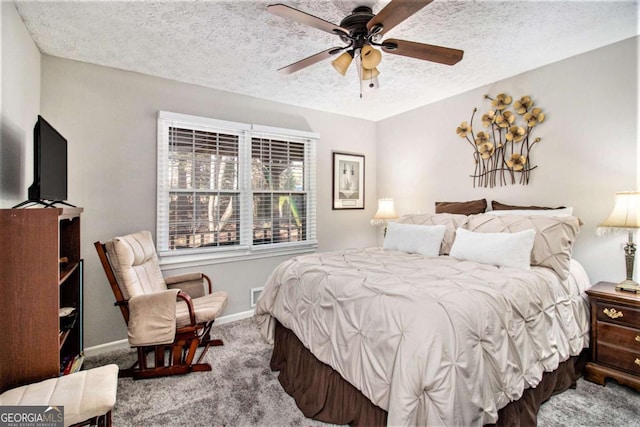 carpeted bedroom featuring ceiling fan and a textured ceiling