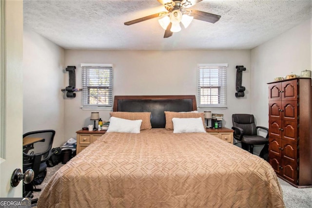 bedroom with carpet, ceiling fan, a textured ceiling, and multiple windows