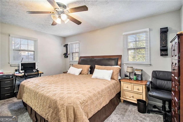 bedroom with ceiling fan and a textured ceiling