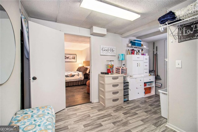 interior space featuring a drop ceiling and light wood-type flooring