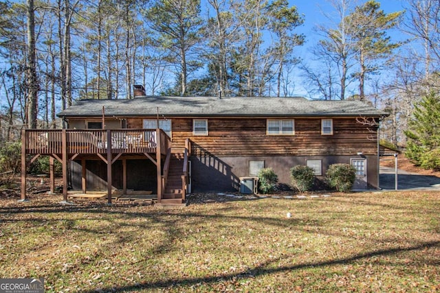 rear view of house featuring a lawn, cooling unit, and a deck