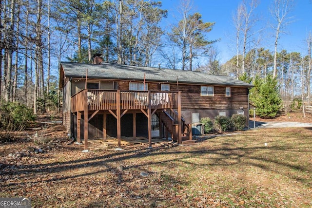 back of property featuring a yard and a wooden deck