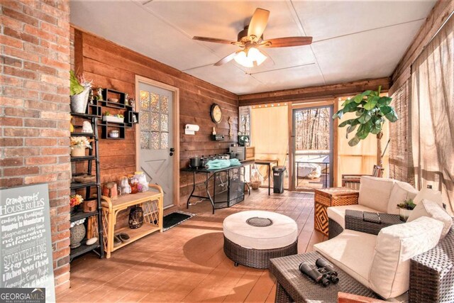 carpeted living room featuring ceiling fan, crown molding, a textured ceiling, and a brick fireplace