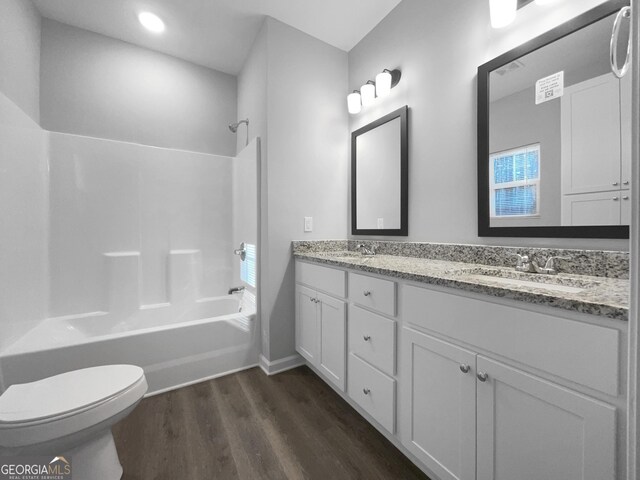 full bathroom with hardwood / wood-style flooring, vanity, toilet, and shower / bathing tub combination