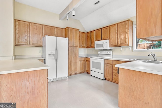 kitchen featuring lofted ceiling, sink, track lighting, and white appliances