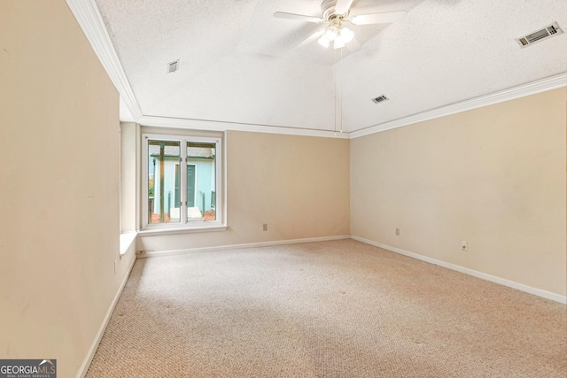 carpeted empty room with ceiling fan, crown molding, vaulted ceiling, and a textured ceiling