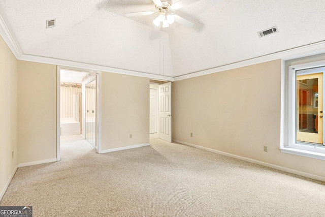 unfurnished room featuring lofted ceiling, ceiling fan, ornamental molding, a textured ceiling, and light colored carpet