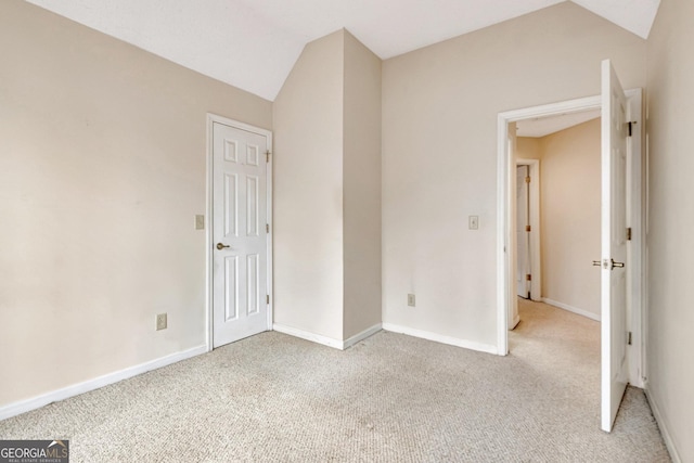 unfurnished bedroom featuring lofted ceiling and light carpet