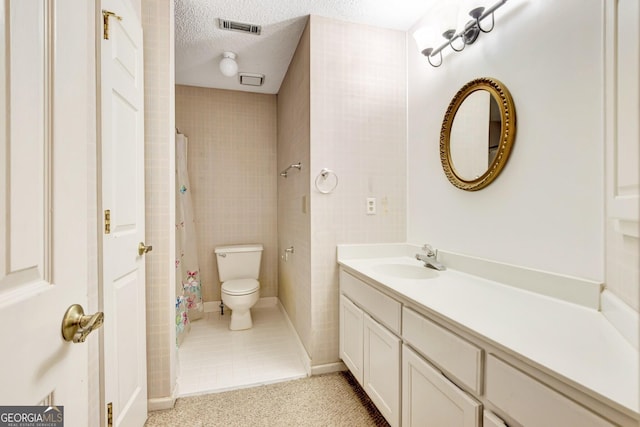 bathroom featuring vanity, toilet, a shower with shower curtain, and a textured ceiling