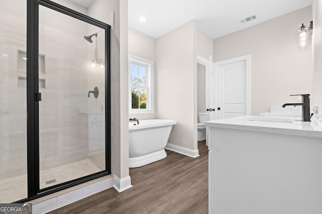 full bathroom featuring wood-type flooring, toilet, vanity, and independent shower and bath