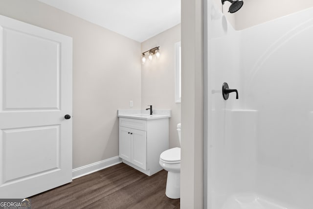 bathroom featuring toilet, walk in shower, wood-type flooring, and vanity