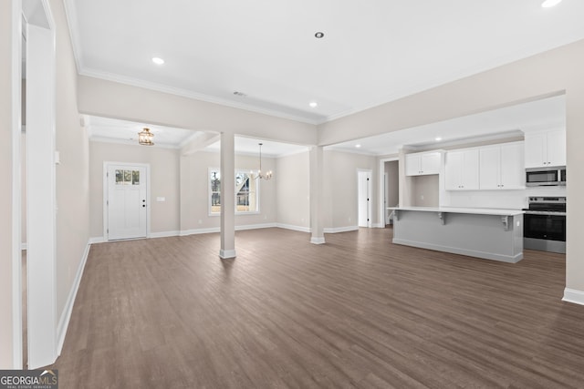 unfurnished living room with crown molding, an inviting chandelier, and hardwood / wood-style floors