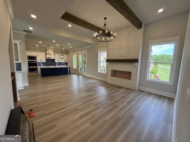 5613 Meadow View Dr, Jefferson, GA 30549 - unfurnished living room featuring baseboards, visible vents, a stone fireplace, and light wood-style floors