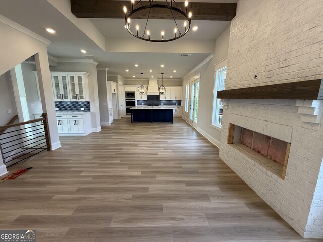 5613 Meadow View Dr, Jefferson, GA 30549 - unfurnished living room featuring a fireplace, light wood finished floors, a chandelier, ornamental molding, and recessed lighting