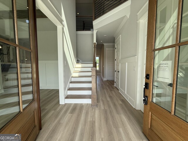 5613 Meadow View Dr, Jefferson, GA 30549 - foyer featuring wainscoting, light wood-style floors, a decorative wall, ornamental molding, and stairway