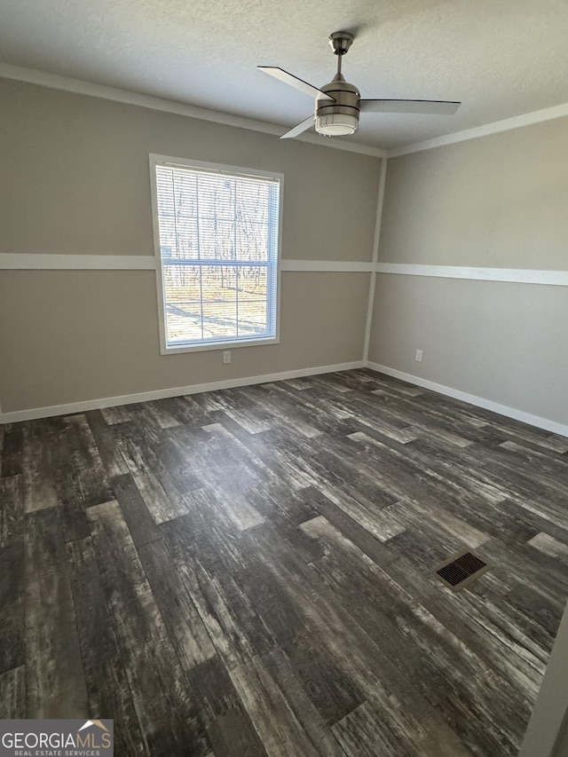 unfurnished room with ceiling fan, crown molding, a textured ceiling, and dark wood-type flooring