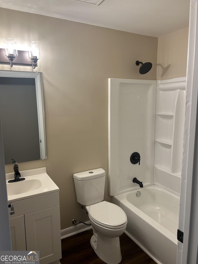 full bathroom featuring toilet, vanity, wood-type flooring, and washtub / shower combination