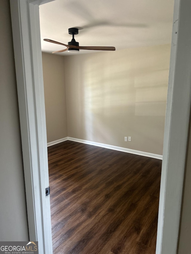 unfurnished room featuring ceiling fan and dark wood-type flooring