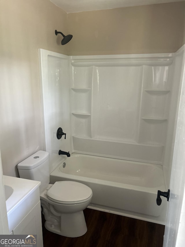 full bathroom with shower / bathing tub combination, vanity, hardwood / wood-style flooring, and toilet