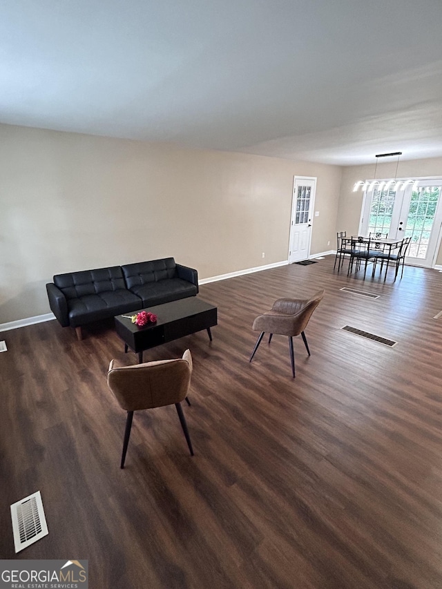 living room featuring dark wood-type flooring and a notable chandelier