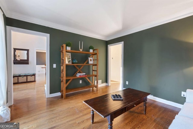 living room with crown molding and light hardwood / wood-style flooring