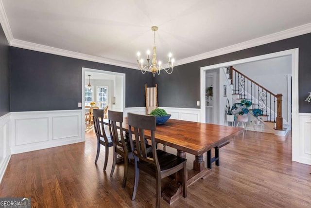 dining area featuring dark hardwood / wood-style flooring, a chandelier, and ornamental molding