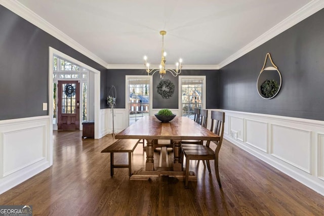 dining room featuring dark hardwood / wood-style flooring, ornamental molding, and an inviting chandelier