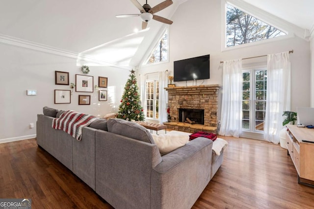 living room featuring ceiling fan, a fireplace, high vaulted ceiling, and dark wood-type flooring