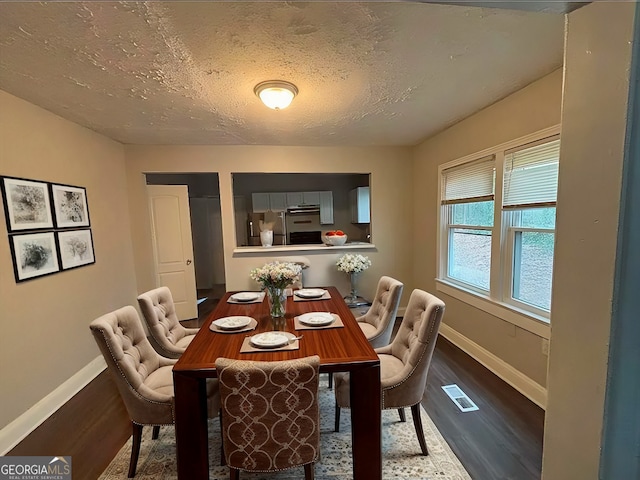 dining room with hardwood / wood-style floors and a textured ceiling