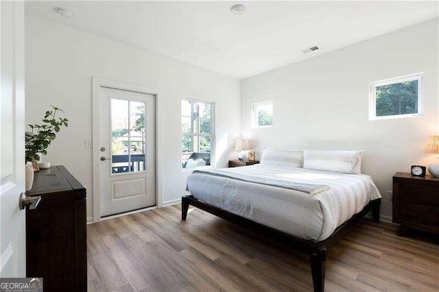 bedroom with hardwood / wood-style flooring and access to outside