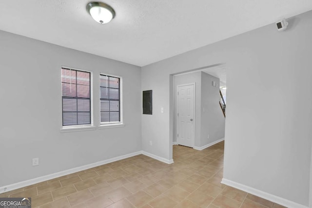 spare room featuring electric panel and a textured ceiling