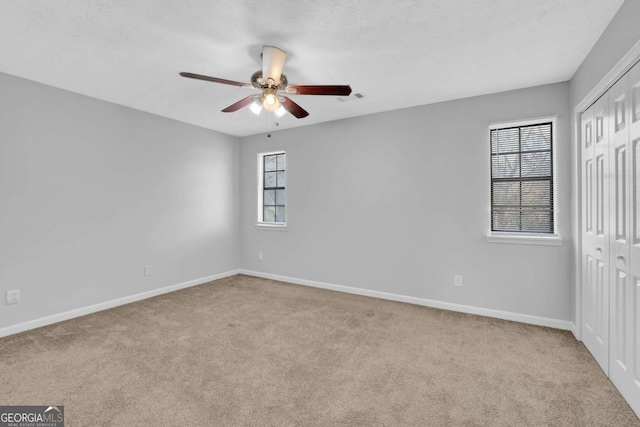 carpeted spare room with ceiling fan