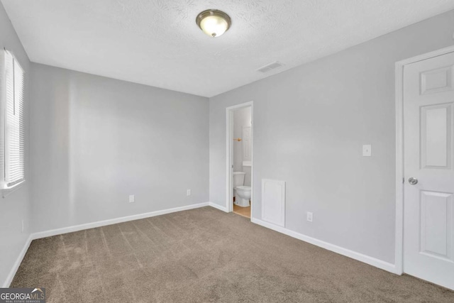 carpeted spare room featuring a textured ceiling