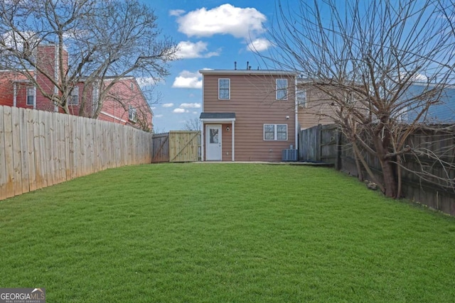 rear view of property with a lawn and central air condition unit